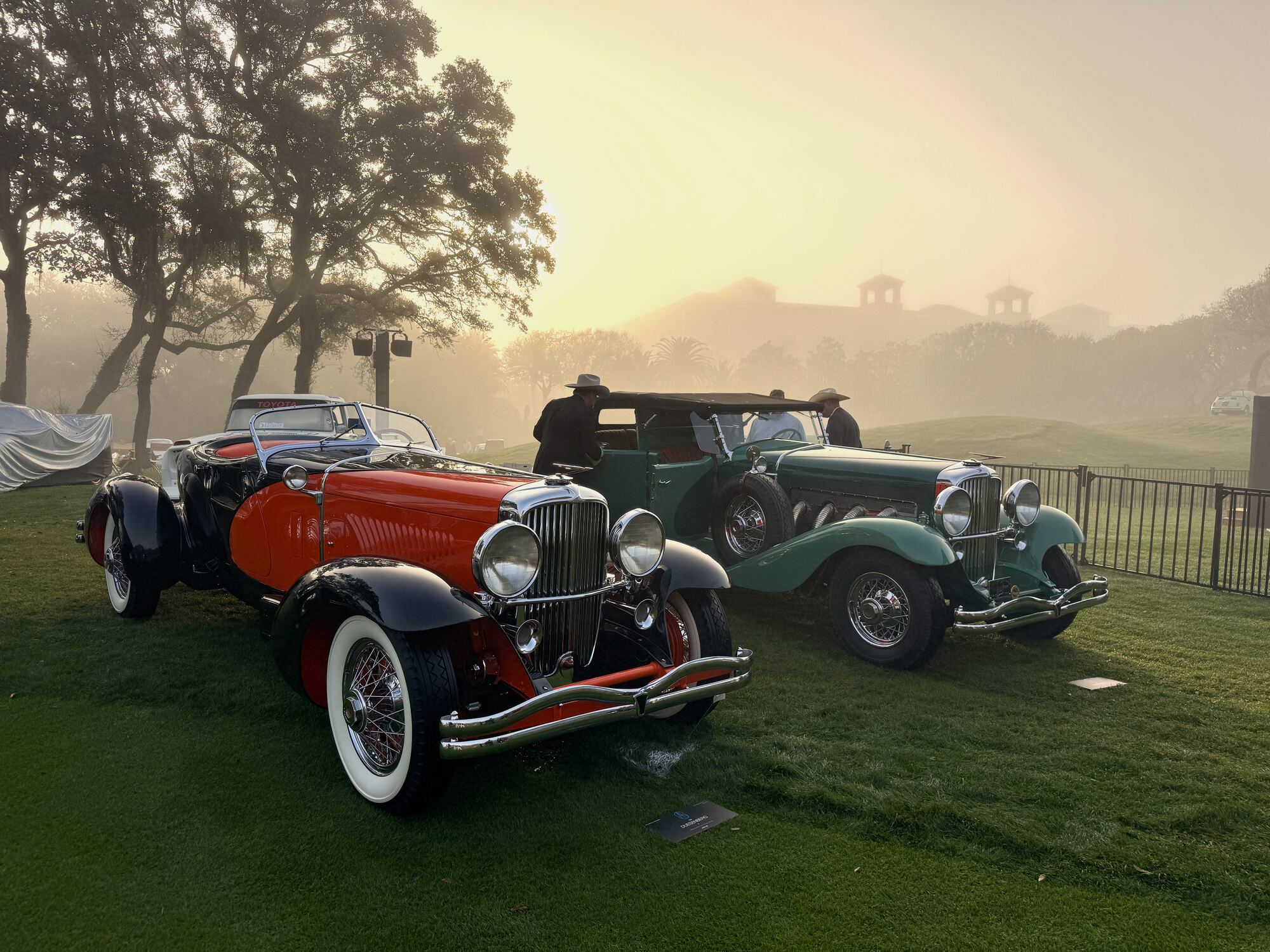 A row of concours Duesenberg roadsters on the misty morning lawn at Pebble Beach